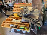 Fishing tackle box trays laid out, showing yellow plastic trays filled with various fishing lures and other fishing accessories.