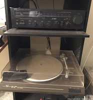 Yamaha receiver on shelf above Dual CS 514 turntable with dust cover closed.