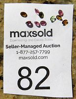 10 multi-coloured tourmaline gemstones displayed on a white card with seller and auction information.