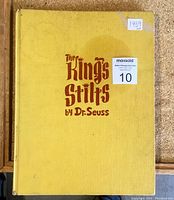 Front cover of vintage hardcover book "The King's Stilts" by Dr. Seuss, showing yellow cover with some stains and red title lettering.