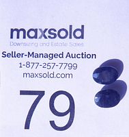 Two oval faceted blue sapphires shown against a white auction card with lot number 79