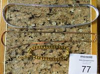 Three chains laid on a granite surface showing the overall look and size difference