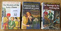 Front covers of three Nancy Drew first edition books with dust jackets: The Mystery of the Ivory Charm, Password to Larkspur Lane, and The Message in the Hollow Oak.