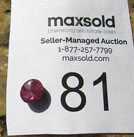 Image of the cat's eye ruby placed on a MaxSold seller-managed auction card with lot number 81 for size reference.