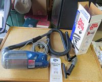 Full view of Dirt Devil handheld vacuum with hose, power cord, box, parts manual, and accessory nozzles