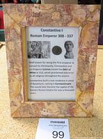 Full view of framed item including map-like border and informative text on Constantine I with coin and statues.