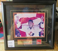 Frontal image of the framed Mario Lemieux photo commemorating gold medal win, showing the plaque and maple leaf emblem clearly.