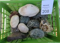 Green basket with assorted rocks including smooth white and dark stones and one with rough texture.