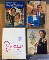 Four vintage royal family and wedding books arranged on surface, including one with notable edge damage.