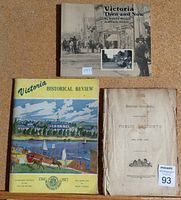 Three vintage and antique British Columbia books displayed on a flat surface: a black and white photo cover book titled "Victoria Then and Now," a colorful illustrated booklet "Victoria Historical Review," and an older worn booklet "British Columbia Public Accounts".