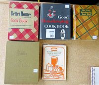 Top view of five vintage cookbooks arranged on a surface.