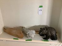 Front view of all three sculptures together on shelf.