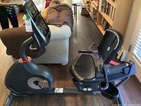 Left-side overview of the full recumbent bike showing frame, seat and console