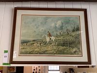 Full view of framed print depicting a hunt scene with rider and dogs in a natural setting.
