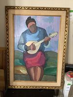 Full view of the framed painting showing the seated figure playing a lute.