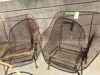 Front view of both mesh patio chairs against concrete wall