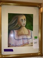 Front view of framed painting showing woman with long hair and colorful blouse, set in ornate gold frame.