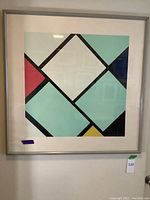 Framed Piet Mondrian art print hanging on wall, showing full artwork and frame