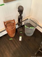 Overview of wooden statue, ice bucket and two wastebaskets