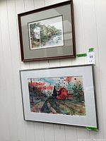 Two framed watercolor paintings hanging on a white wall, showing overall condition and size.