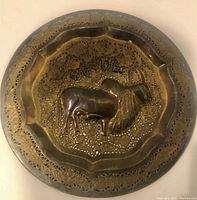 Top-down view of the antique brass plate showing detailed filigree and bull motif.