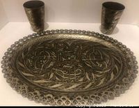 Photo of the metal tray and two matching cups from a front angle showing size and design detail.