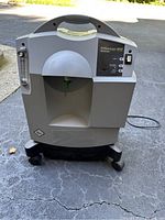 Front view of unit showing gray plastic housing with carrying handle and wheeled base
