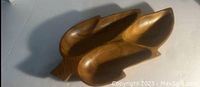 Carved wooden candy dish tray with leaf shape and sections visible on neutral background.