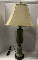 Front view of the vintage green glass flower lamp with fabric shade