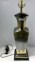 Full front view of the lamp showing the silver body with gold decorative accents and black base with gold trim. Includes lamp socket and cord with switch.