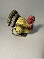 Side angle of the vintage ceramic turkey figurine showing detailed textured feathers and vibrant colors.