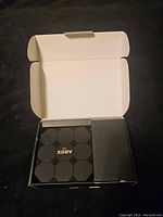 Top view of opened box showing ABOX TV Box and accessories inside two separate compartments.