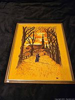 Framed vintage tapestry showing fall foliage and a distant church spire with a figure walking on the path under trees.
