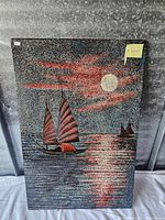 Front view of wood wall art showing sailboats under moonlit sky with red clouds, featuring textured speckled surface.