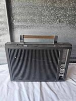 Front view of the vintage Lloyds portable radio showing black grille, tuning dial, and control knobs.