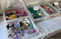 Top view showing five plastic drawers filled with various kids craft supplies including colored buttons, beads, pom-poms, and wooden sticks.