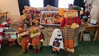 View of entire lot showing floral wreaths, scarecrows, and ghost figure on couch and floor