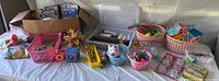 Wide view of various children's fidget toys, baskets with colorful pop-its, silicone sensory toys, stackable items, and children's books in a box.