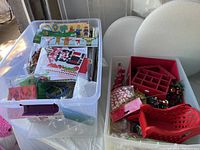 Clear bin mostly filled with packaged kids craft projects and kits, colorful with Christmas motifs