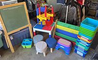 Full view of easel, LEGO table, stools, bookshelf, and storage bins
