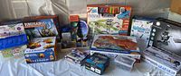 Wide view of toddler and kids STEM toys and puzzles lot laid out, including puzzle boxes, construction kits, and science activity sets.