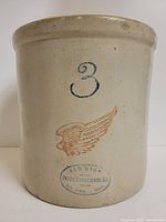 Front view of the beige stoneware crock showing blue number 3, red wing emblem and blue Red Wing Union Stoneware Co. stamp.