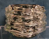 Art glass votive candle holder showing clear glass strands wrapped around a smoky glass core, viewed from a slightly elevated angle.