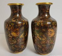 Front and side view of two brown floral cloisonne vases with gold rims.