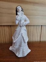 Front left angle view of Royal Doulton figurine 'Hope' in white textured dress and coat.