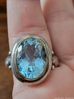 Front view showing oval faceted light blue aquamarine in 22K gold bezel setting on solid sterling silver band.