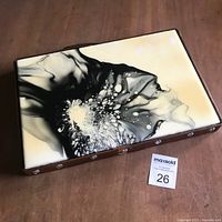 Full view of abstract resin board art showing fluid black and white design with leather edge frame.