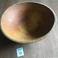 Large hand turned maple wood bowl with smooth surface and natural wood tones.