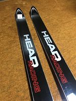 Top surface of the skis showing HEAD RACING branding in white and red on a black background.