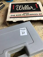 White plastic carrying case with Weller cardboard outer box, showing branding and kit model number 8200 PK soldering kit.